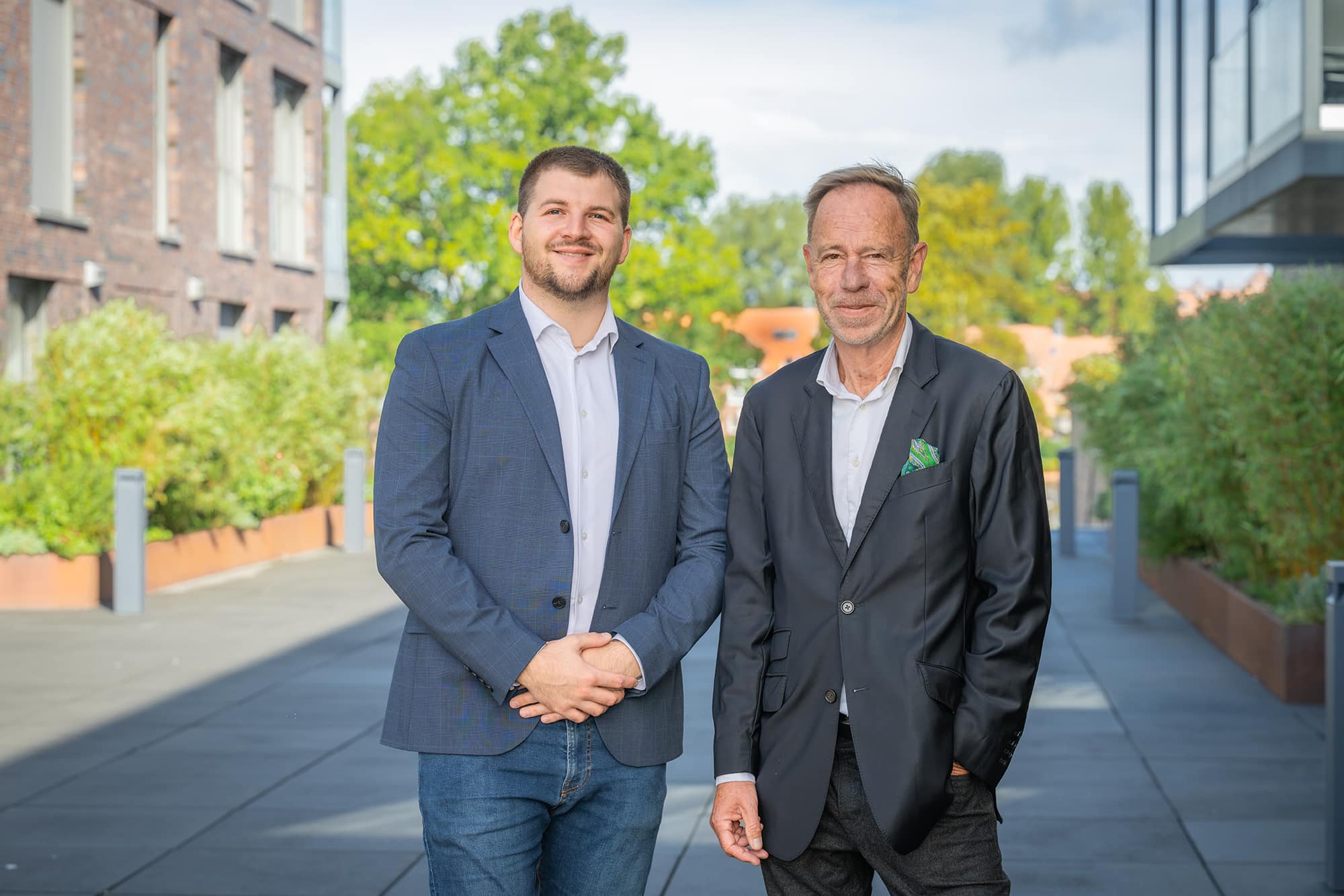 Zwei Mitarbeiter von KLUG Immobilien im Gespräch vor einem Gebäude